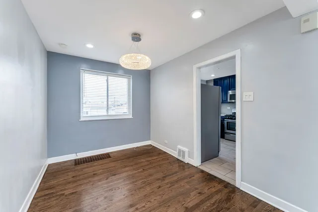 an empty room with wooden floor and window