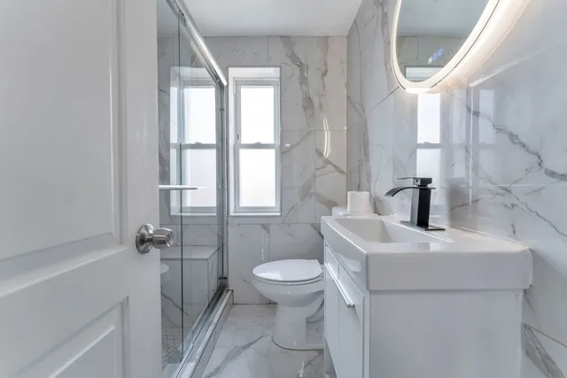 a bathroom with a sink a toilet and a mirror