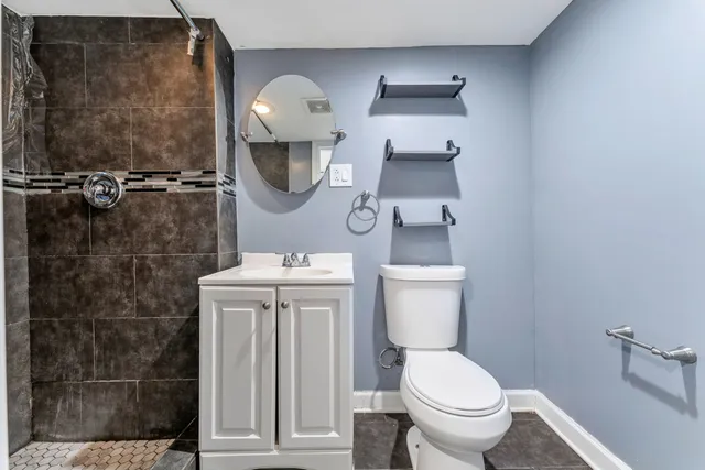 a bathroom with a toilet a sink and mirror