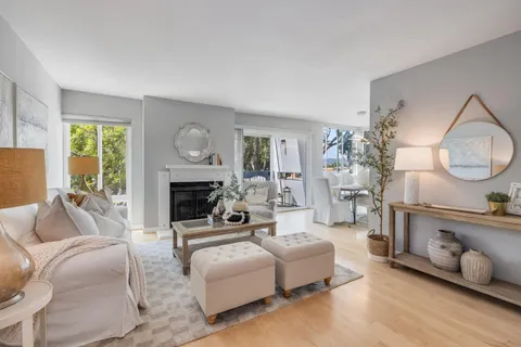 a living room with furniture a fireplace and a large window