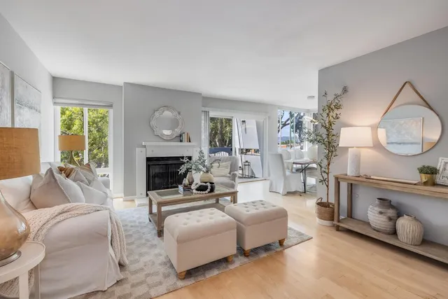 a living room with furniture a fireplace and a large window