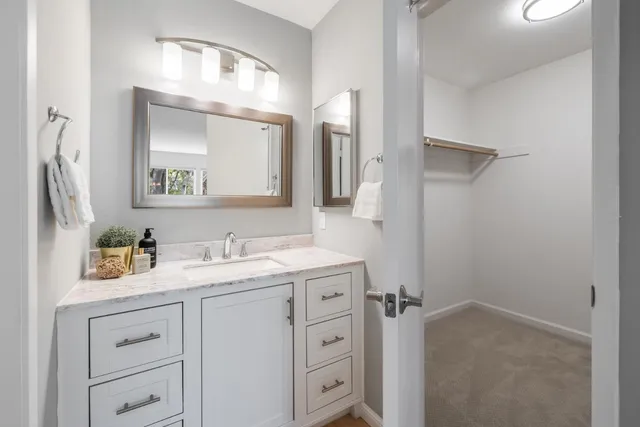 a bathroom with a granite countertop sink vanity mirror next to a cabinet