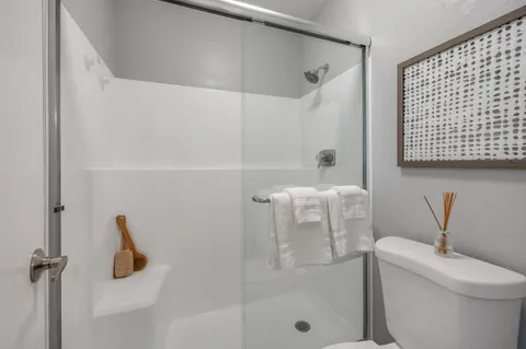 a bathroom with a toilet and a shower