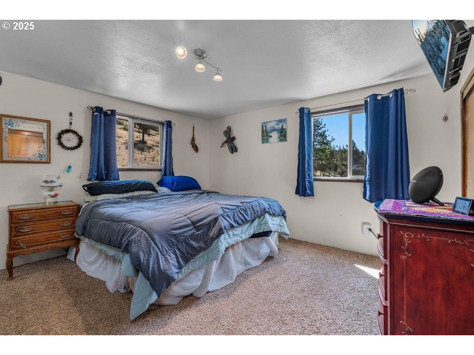 4800 Mill Creek Road Prineville, OR 97754 - Photo 15 of 40 a bedroom with a bed window and dresser