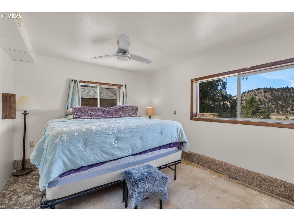 4800 Mill Creek Road Prineville, OR 97754 - Photo 21 of 40 a bedroom with a bed a dresser and painting on the wall