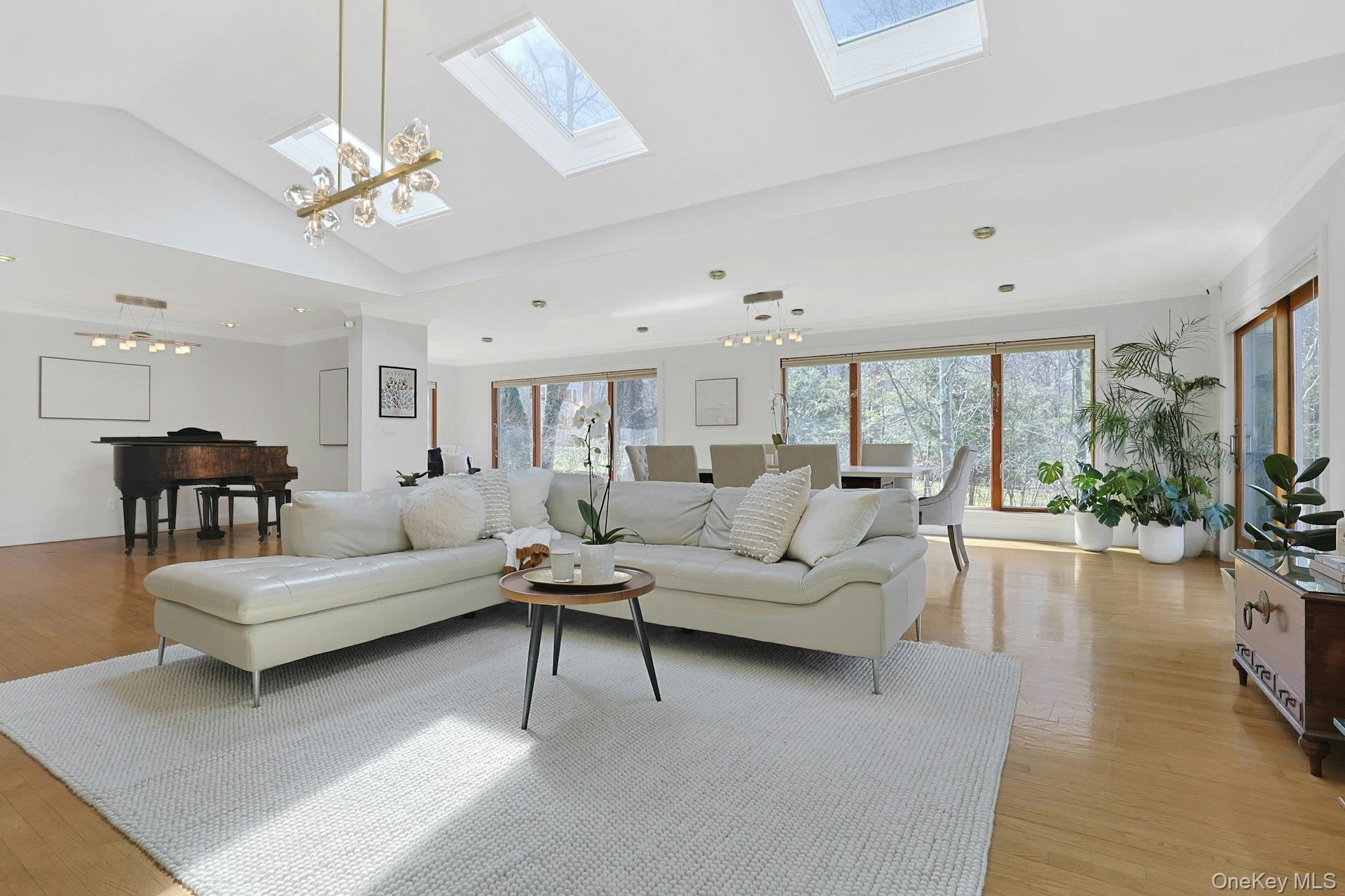 45 Sprain Valley Road Scarsdale, NY 10583 - Photo 3 of 26 Streaming with sunshine, this expansive, open-plan living and dining area has three large skylights and is framed by walls of windows and sliding doors that open to the oversized deck, offering sweeping views of the park-like backyard.