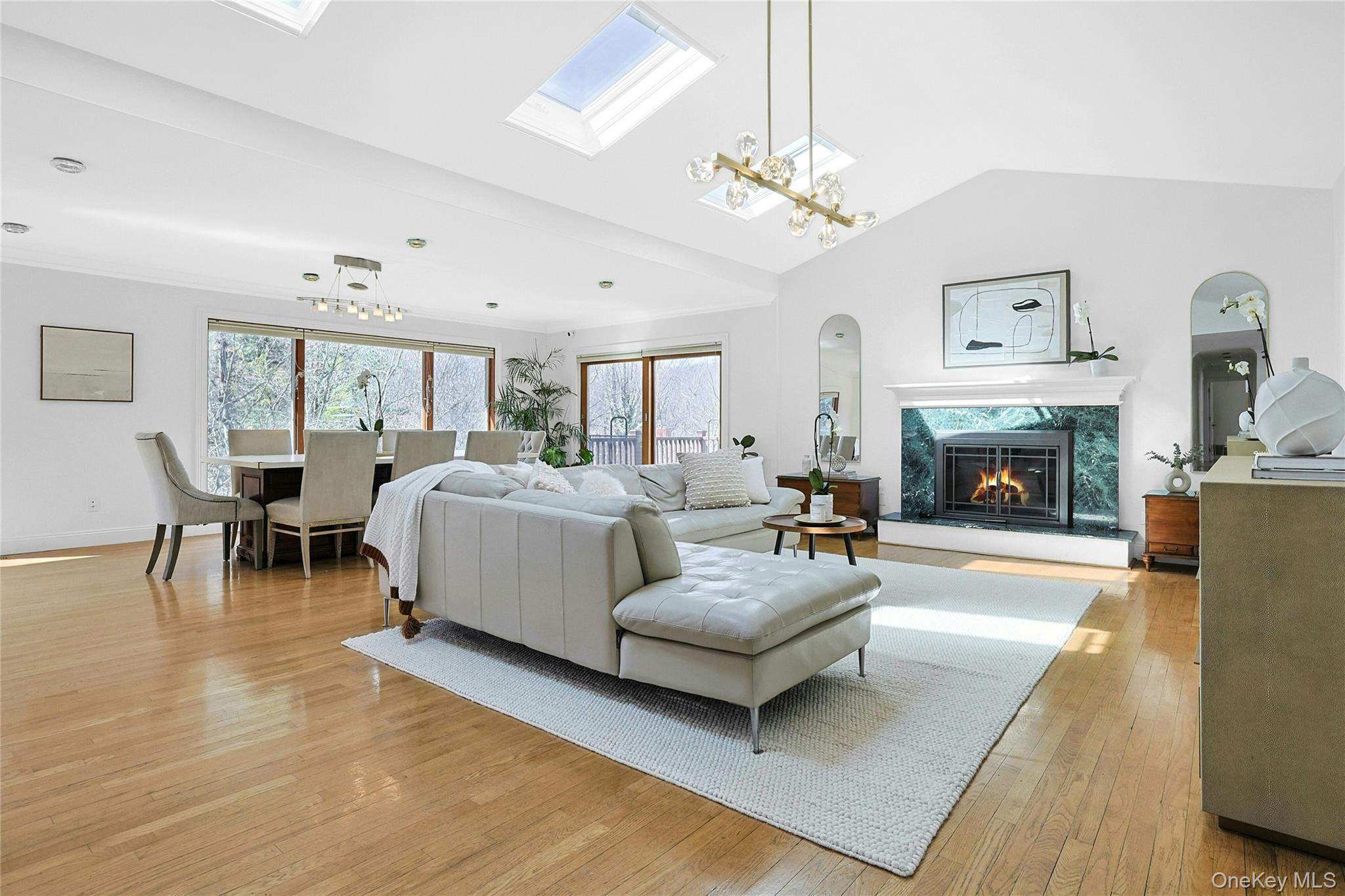 45 Sprain Valley Road Scarsdale, NY 10583 - Photo 4 of 26 The main living space is anchored by a wood-burning fireplace and enhanced by vaulted ceilings, three skylights, and walls of windows that flood the room with natural light and capture views of the surrounding property.