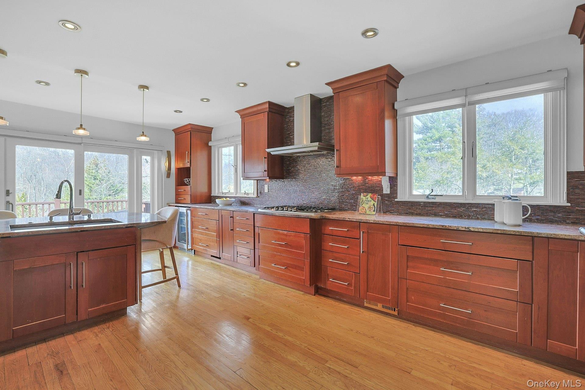 45 Sprain Valley Road Scarsdale, NY 10583 - Photo 10 of 26 Another view of the eat-in kitchen highlights the generous counter space, extensive cabinetry, and natural light streaming through surrounding windows.