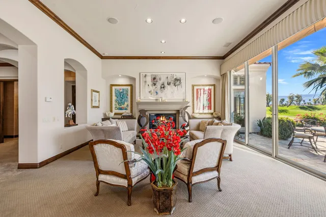 a living room with furniture a chandelier and a large window
