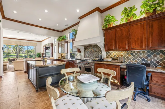 a bathroom with a granite countertop sink two mirror and a refrigerator