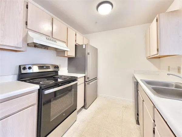 a kitchen with stainless steel appliances granite countertop a sink stove and refrigerator