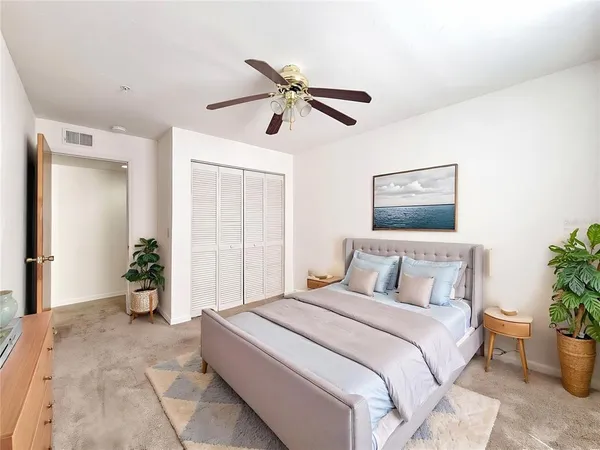 a bedroom with a large bed and potted plant