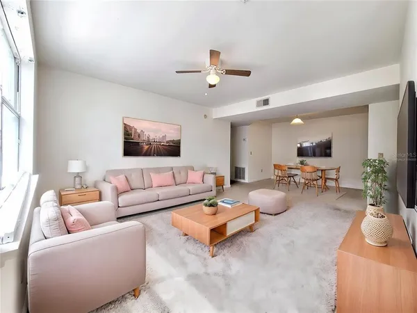a living room with furniture and a ceiling fan