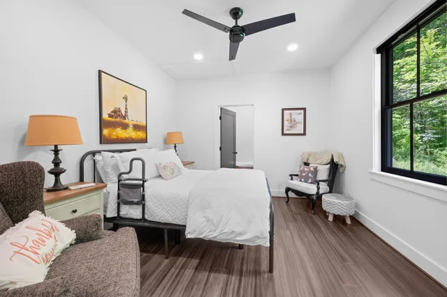 a bedroom with double bed windows and a rug