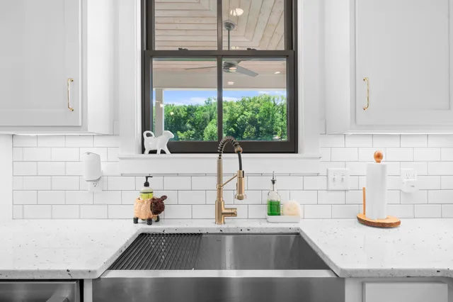a kitchen with stainless steel appliances sink a stove and cabinets