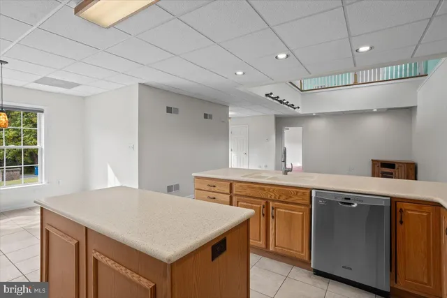 a kitchen with a stove a sink a refrigerator and chairs