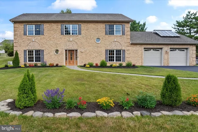 a front view of a house with a garden