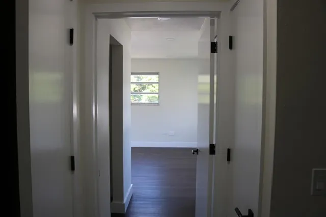 a view of a hallway with wooden floor
