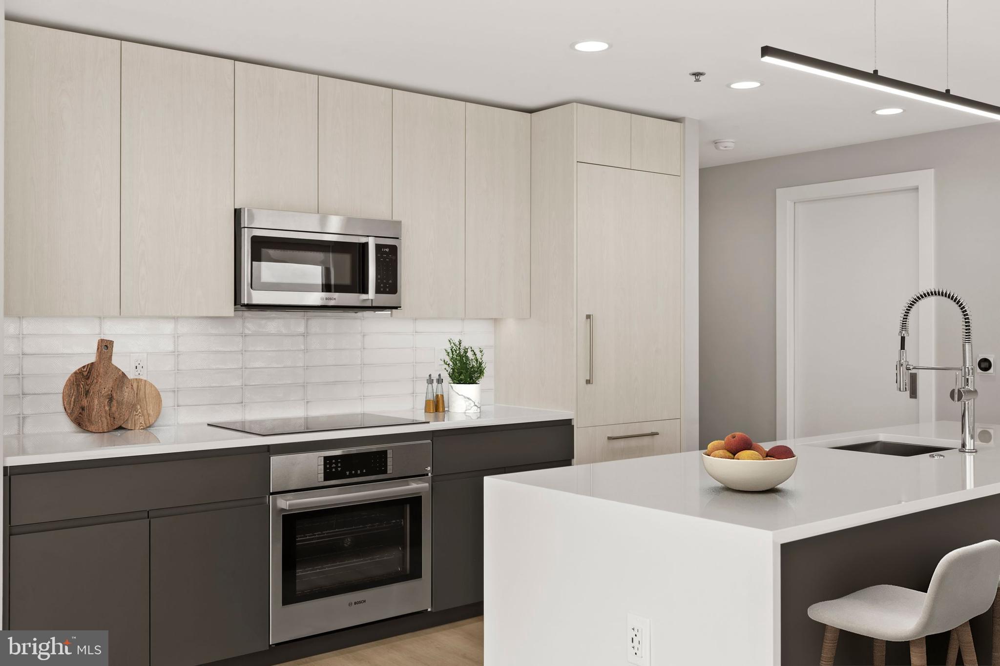950 3rd Street Northwest, Unit PH1306 Washington, DC 20001 - Photo 23 of 37 a kitchen with stainless steel appliances a sink a stove a microwave a sink and cabinets