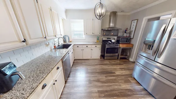 a kitchen with granite countertop a refrigerator stove and sink