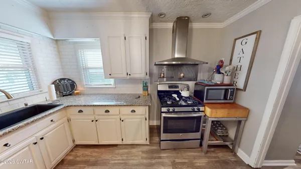a kitchen with stainless steel appliances a stove and cabinets