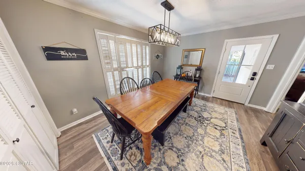 a room with chandelier fan and wooden floor