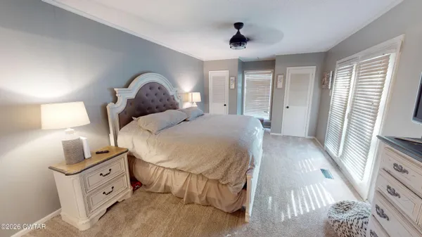 a bedroom with a bed and a tv on the dresser