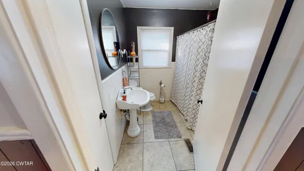 a bathroom with a sink and mirror with toilet