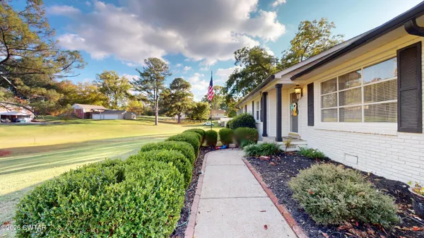 a view of a house with a yard and potted plants