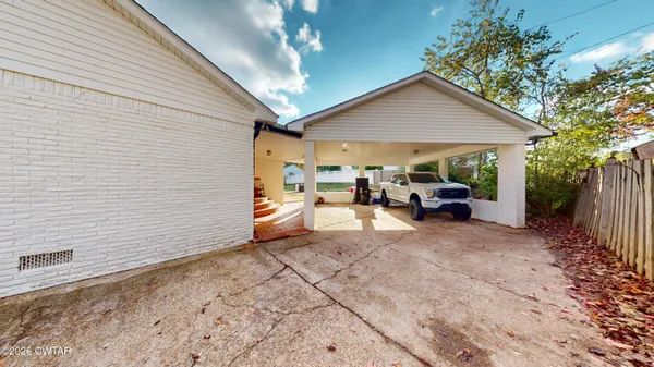a view of a patio with table and chairs under an umbrella