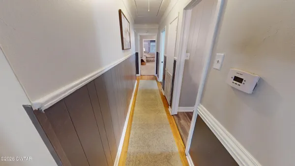 a view of a hallway with wooden floor and stairs