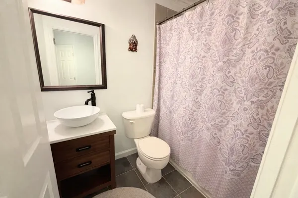 a bathroom with a toilet sink vanity and mirror