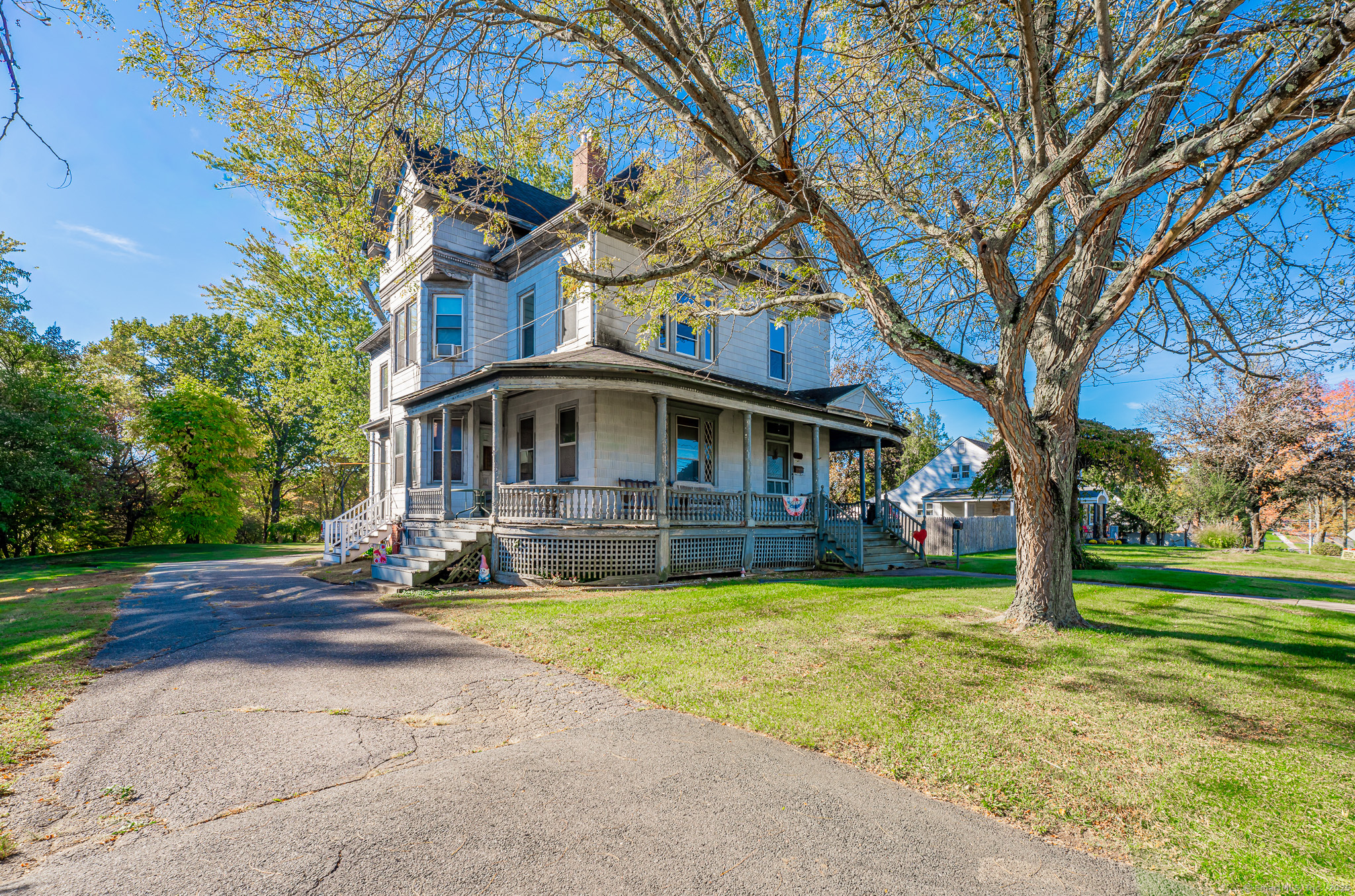a view of a house with a big yard and large trees
