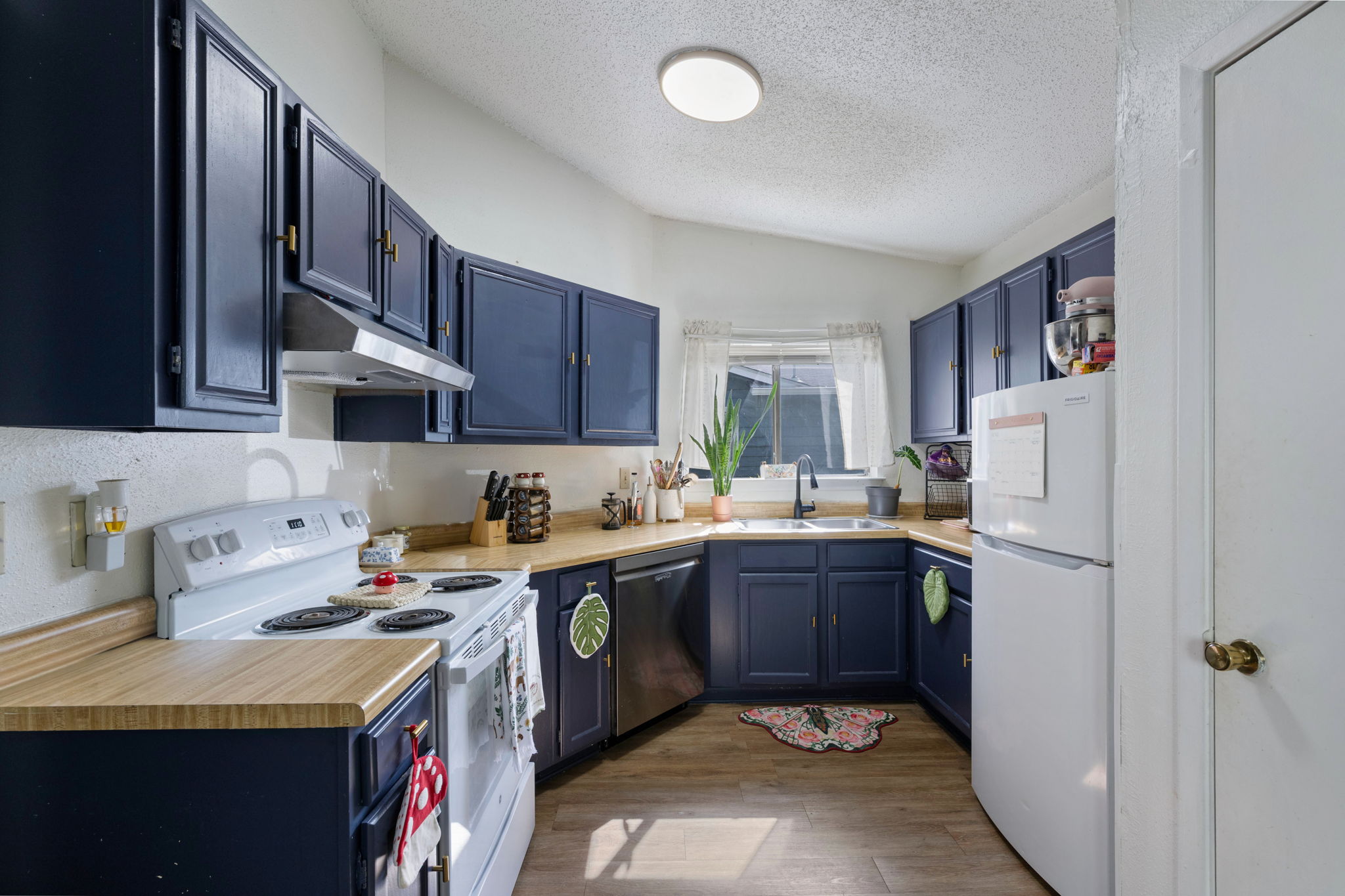 8317 Forest Ridge Drive San Antonio, TX 78239 - Photo 10 of 26 A well-equipped kitchen featuring ample navy cabinetry, wood countertops, and modern appliances.