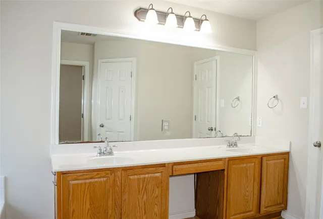 a bathroom with a double vanity sink and a mirror