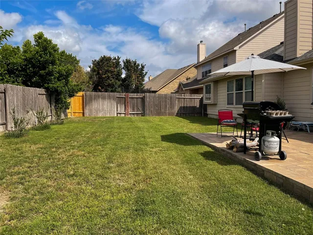 a view of a house with backyard and sitting area