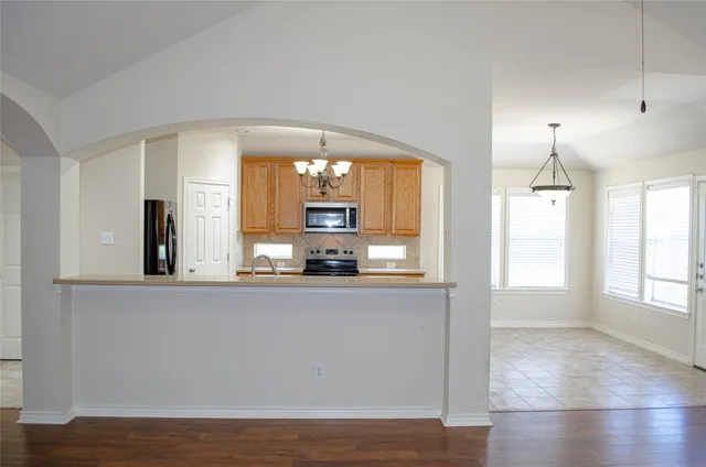 a view of a kitchen with wooden floor and windows