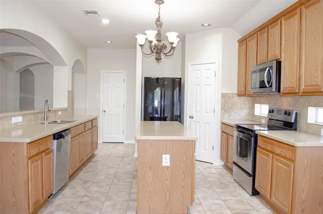 a large kitchen with stainless steel appliances granite countertop a stove and a sink