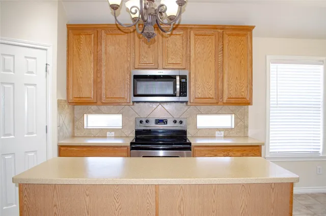 a kitchen with granite countertop a stove and a microwave