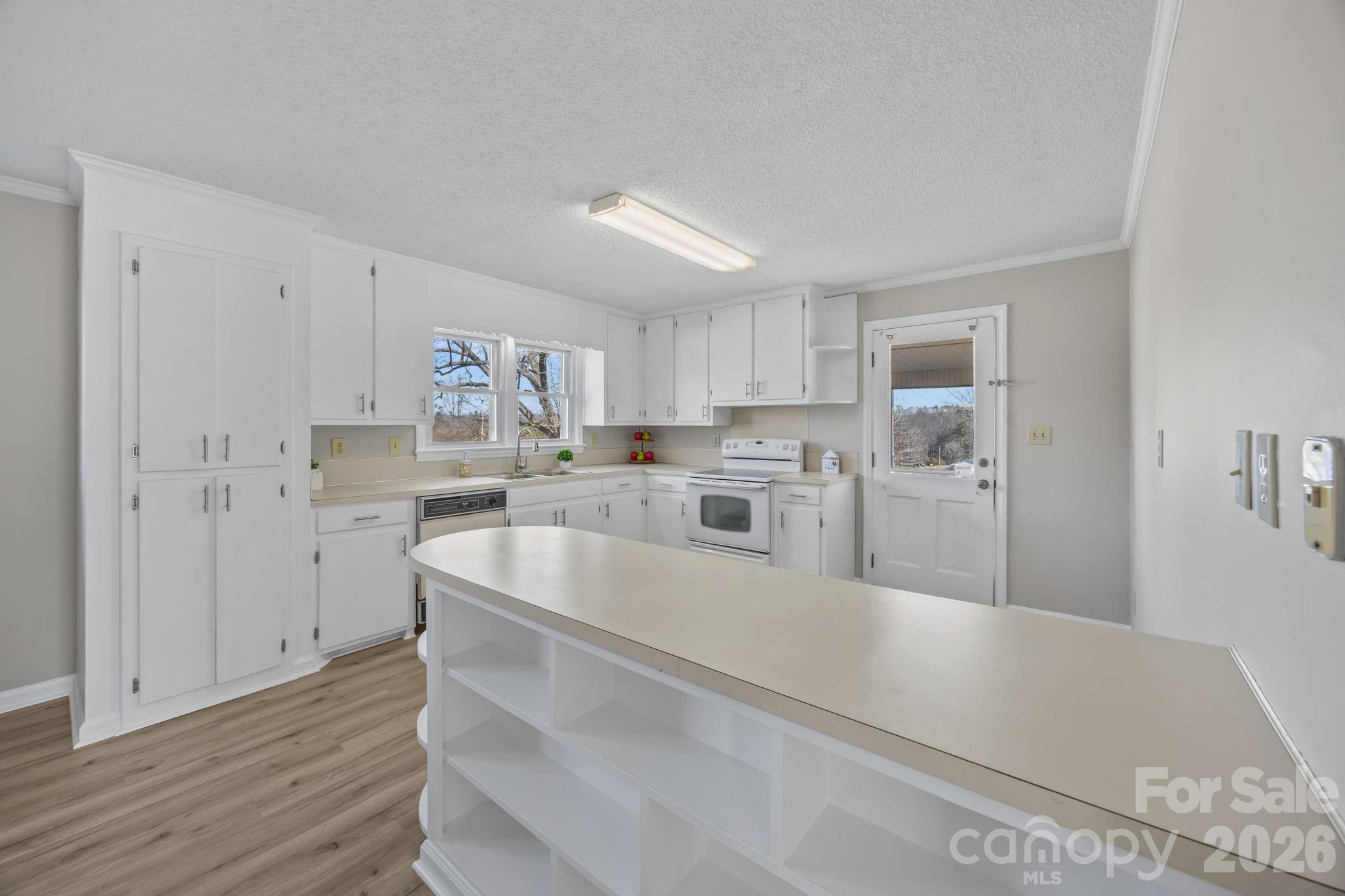 33633 Mann Road Albemarle, NC 28001 - Photo 21 of 39 a kitchen with white cabinets and stainless steel appliances