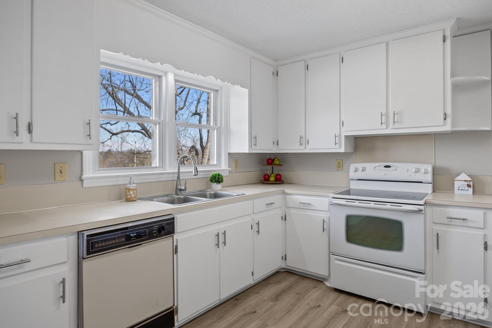 33633 Mann Road Albemarle, NC 28001 - Photo 24 of 39 a kitchen with white cabinets and white appliances