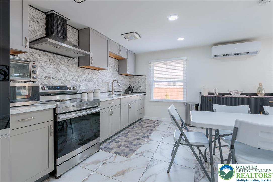 38 Water Street Wind Gap, PA 18091 - Photo 8 of 37 a kitchen with stainless steel appliances granite countertop a sink a stove a microwave a dining table and chairs