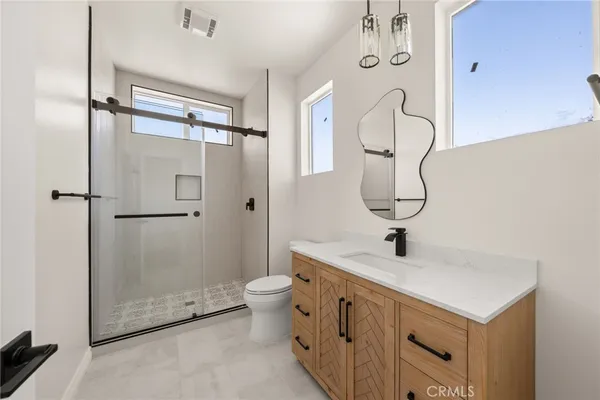 a bathroom with a double vanity sink mirror and shower