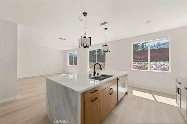 a spacious bathroom with a granite countertop sink and a wooden floor