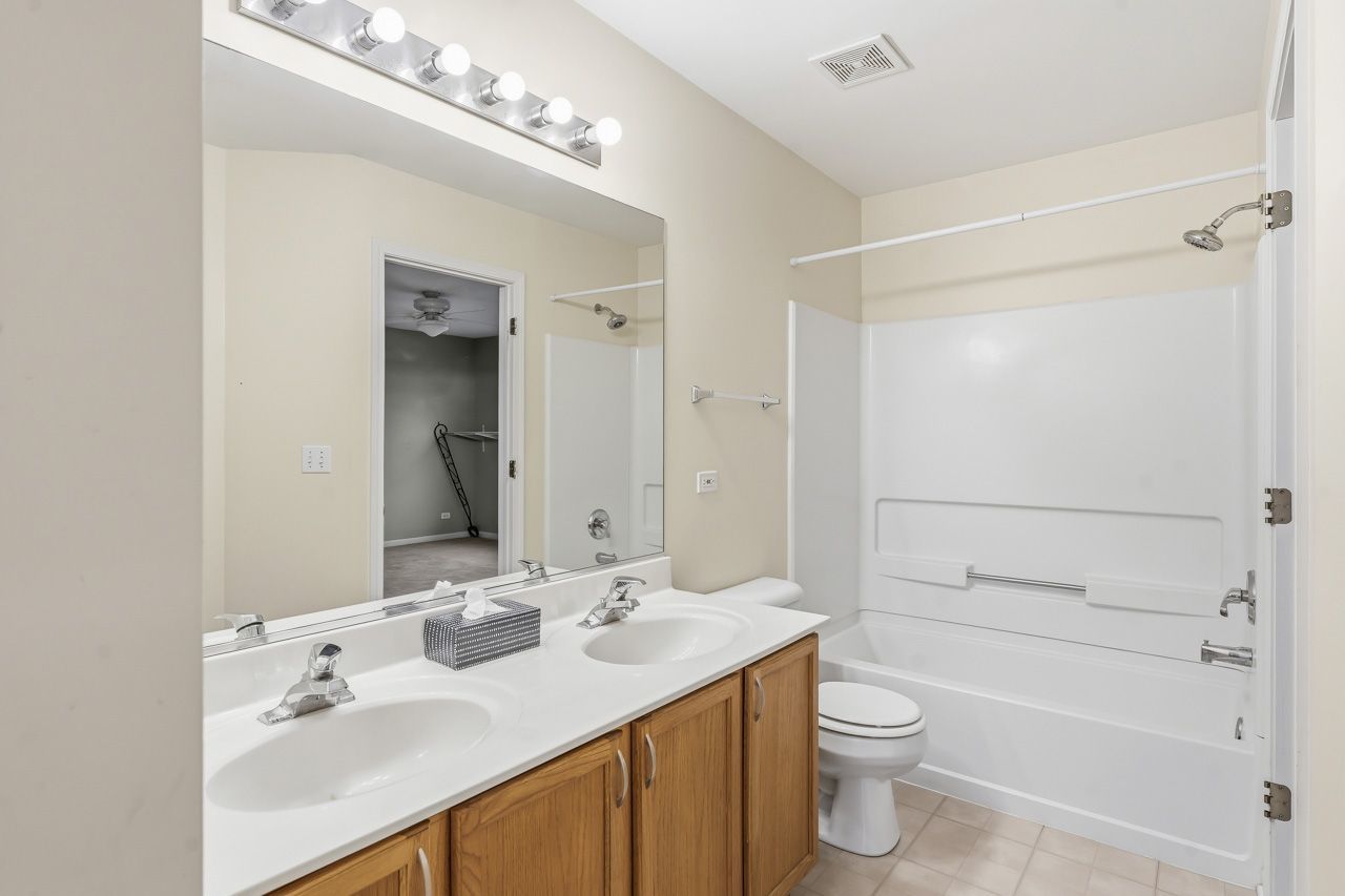 335 Holiday Lane Round Lake, IL 60073 - Photo 14 of 25 a bathroom with a sink a toilet and shower