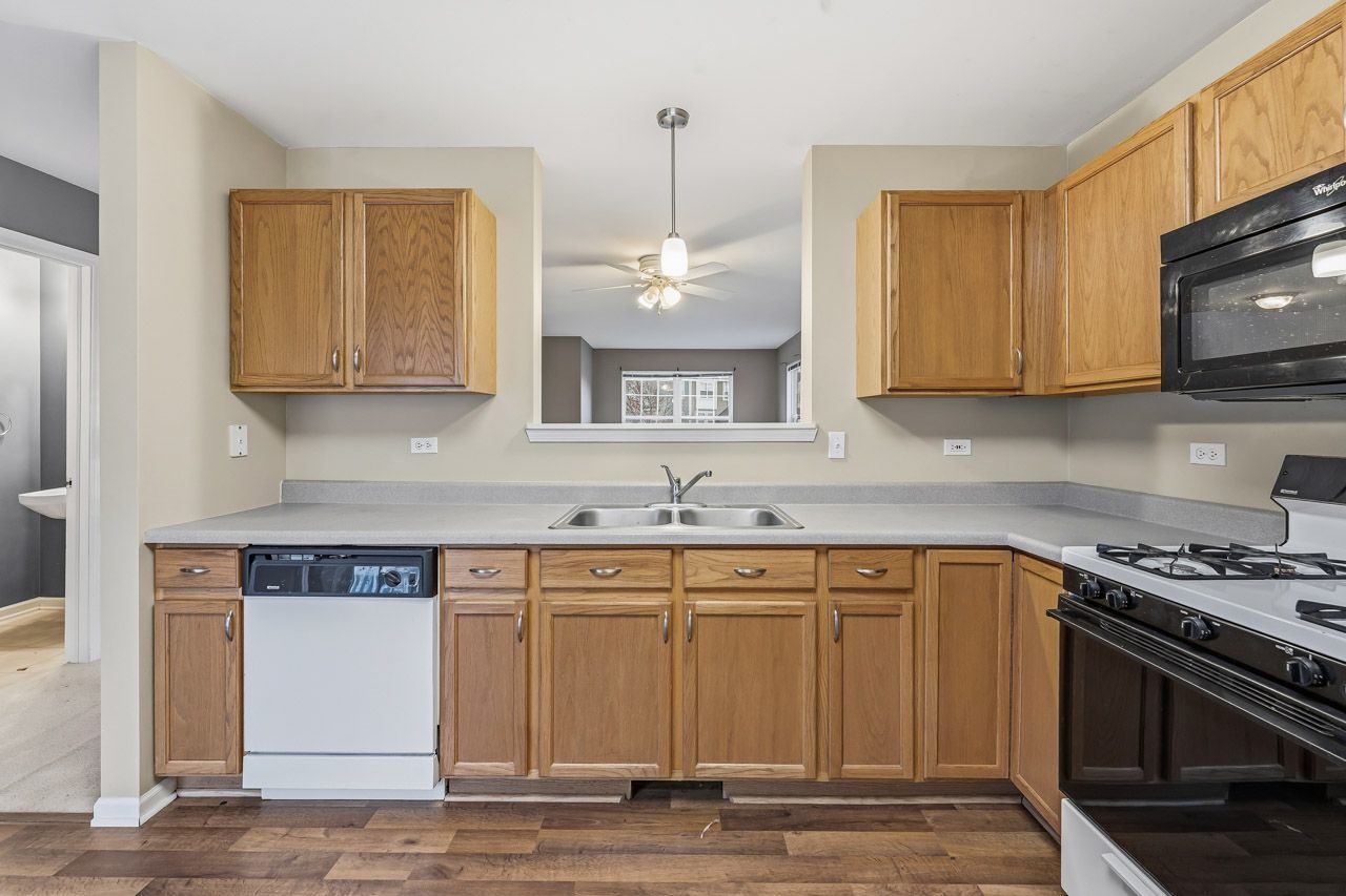 335 Holiday Lane Round Lake, IL 60073 - Photo 9 of 25 a kitchen with stainless steel appliances granite countertop a sink stove and microwave
