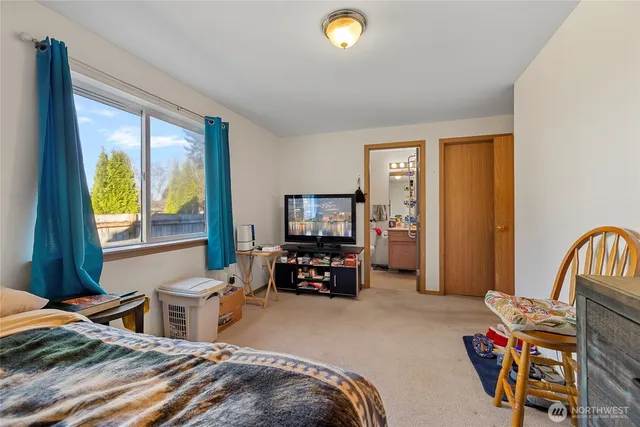 a bedroom with furniture and a flat screen tv