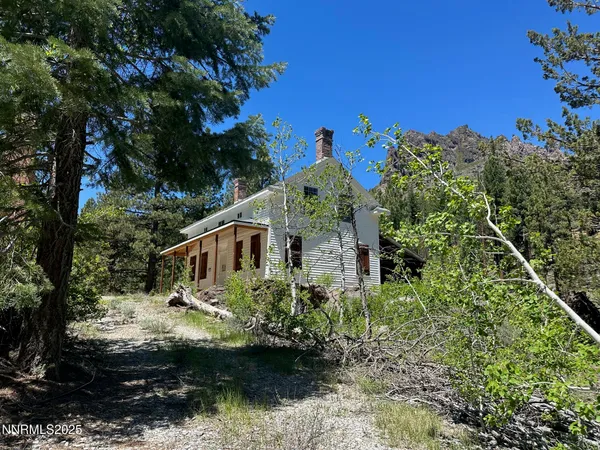 a front view of a house with a yard and potted plants