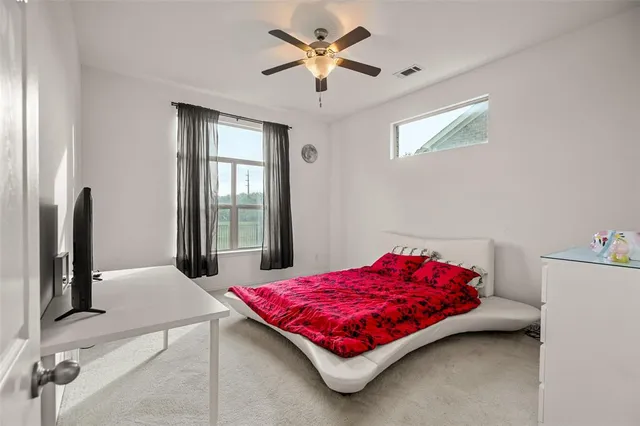 a living room with a bed and a flat screen tv