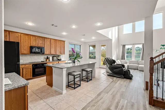 a kitchen with stainless steel appliances granite countertop a refrigerator sink and stove